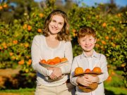 mom and son holding citrus freshly picked at u-pick citrus farm prior to monster truck tour while on original orlando tours