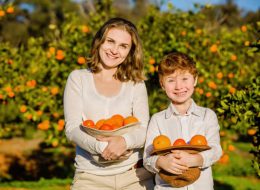 mom and son holding citrus freshly picked at u-pick citrus farm prior to monster truck tour while on original orlando tours